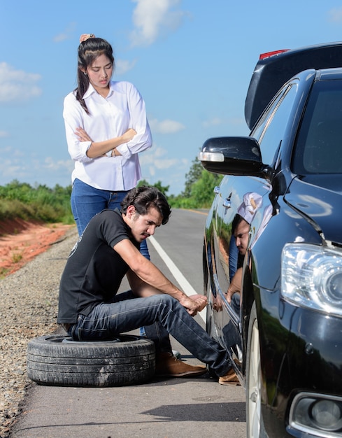 Broken wheel man changing tire help female friends