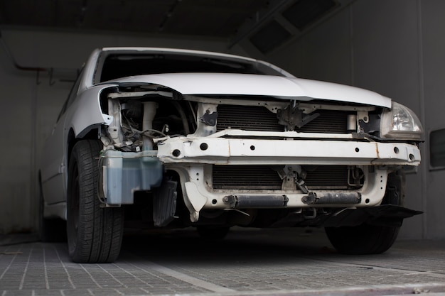 Broken white car in the garage