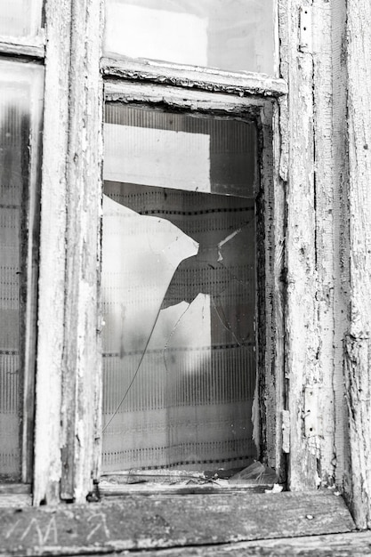 Broken Window of an old abandoned house black and white image