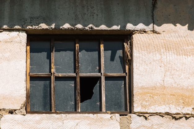 Broken window in an old building because of an abandoned one