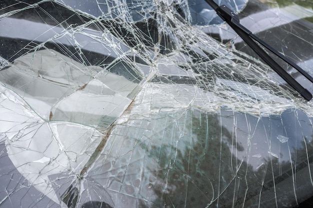 The broken windshield in car accident beaten frontal glass