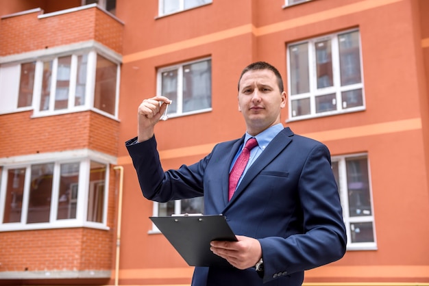 Broker with key from new apartment near new house