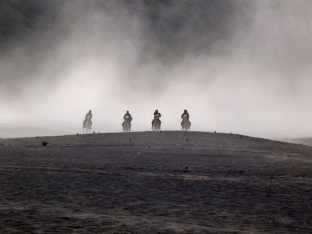 Bromo desert e horse riders durante la tempesta di sabbia a bromo