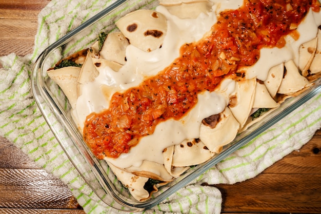 Bron van zelfgemaakte spinaziecannelloni met bechamelsaus en filetto. Concept van thuis koken, gezond eten, natuurlijk.