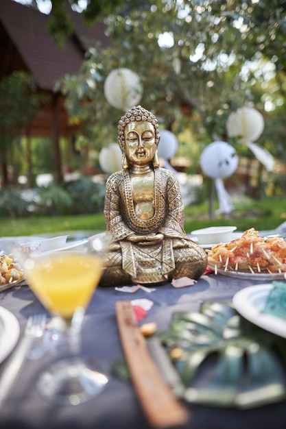 Bronze Buddha figurine in nature at a picnic closeup of the Buddha figurine