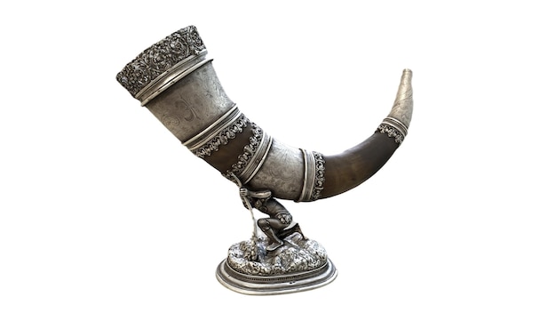 A bronze horn with a design on the front.