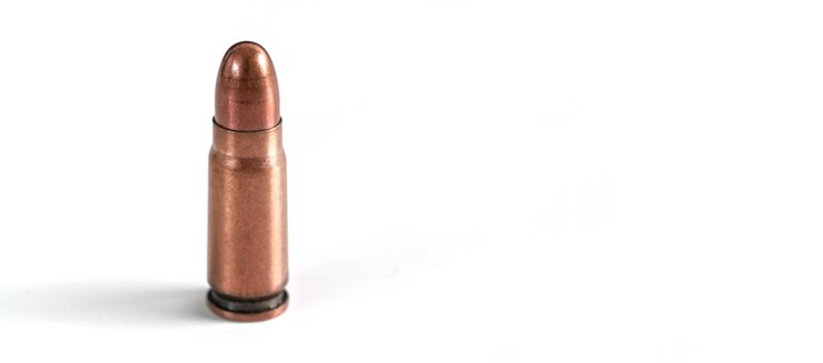 Photo bronze pistol bullet isolated on white, space for text right side