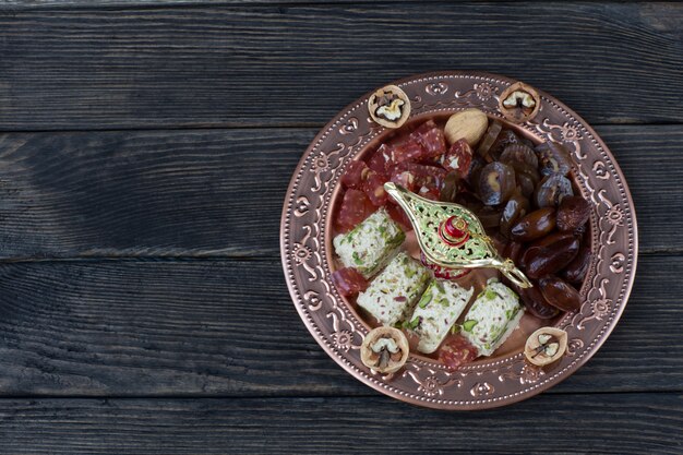 in a bronze plate dates, walnuts, halva, Turkish delight and walnuts 