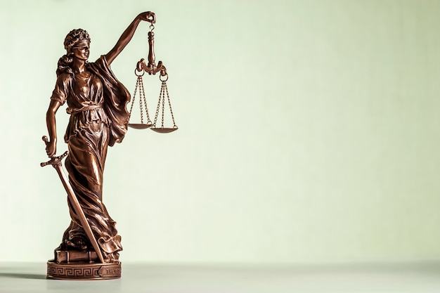 bronze statue of justice with sword and scales