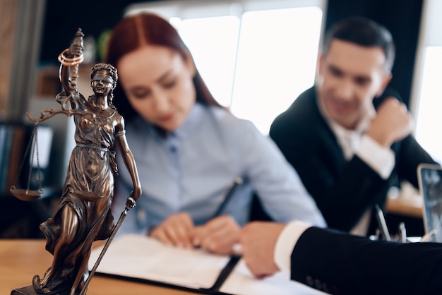 Bronze statue of Themis holds scales of justice in office.