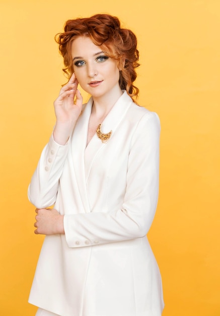 Foto spilla di colore dorato a forma di luna su una giacca bianca di una ragazza dai capelli rossi
