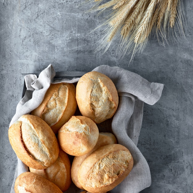 Brood broodjes in mand op rustiek hout met tarwe oren