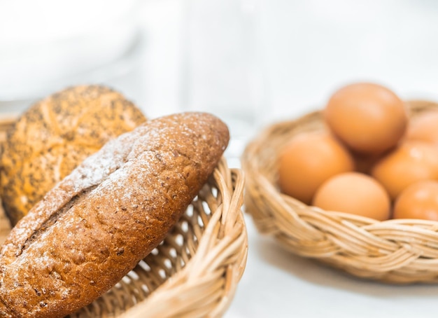 Brood eimelk op keukenbar voor ontbijt die voor familie in witte huiskeuken voorbereidingen treft