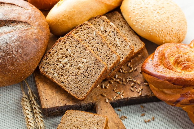 Brood en aartjes van tarwe op een houten achtergrond