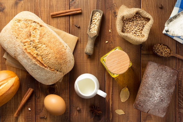 Foto brood en bakkerij-ingrediënten op houten tafel achtergrond, bovenaanzicht