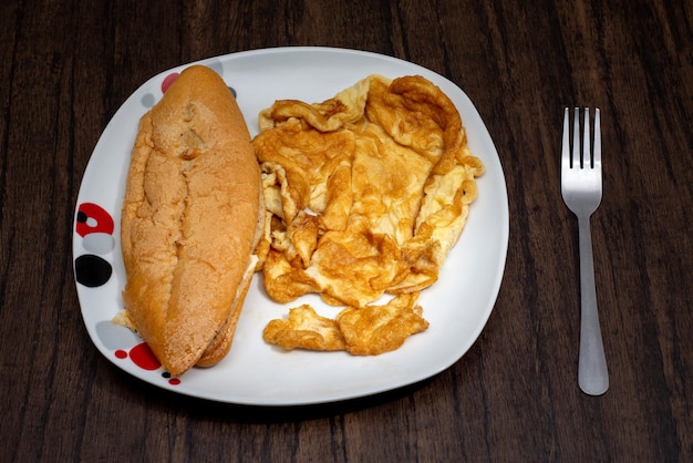 Brood en ei omelet geserveerd op een bord op houten tafel