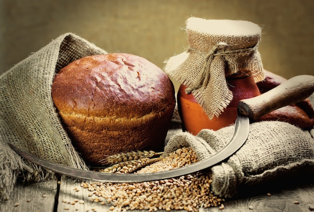 Brood en tarwekorrels op een houten achtergrond