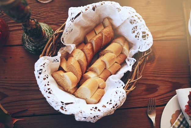 Brood eten en mand met een voorgerecht serveren op een houten eettafel in een huis voor een feestelijk evenement Feestlunch en mutrition met een stokbrood op een oppervlak om te eten, dineren of een maaltijd