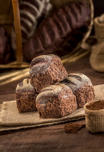 Brood gemaakt met cacau en chocolade op rustieke doek op rustieke houten tafel met ingrediënten.