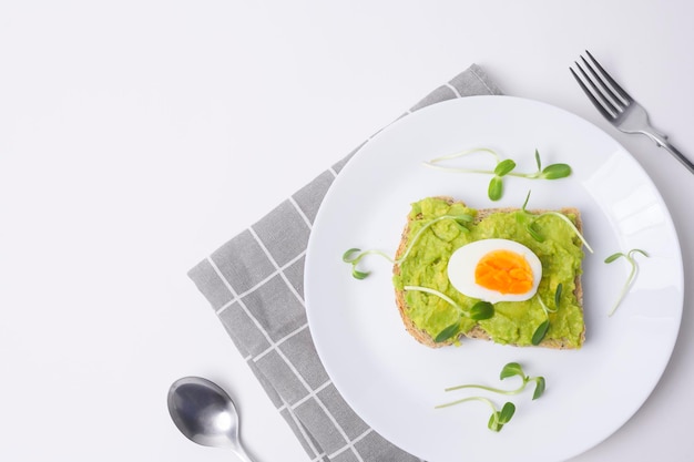 Brood met avocado groenten fruit en ei op witte achtergrond Gezond ontbijt concept