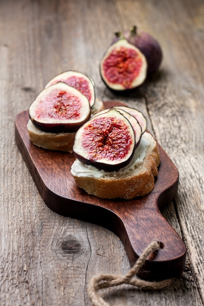 Foto brood met vijgen, ricotta op oude houten achtergrond