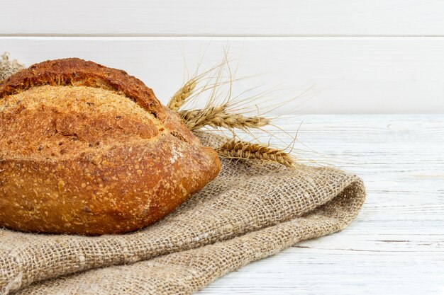 Brood op tafel, zelfgebakken brood met tarwe op een houten achtergrond