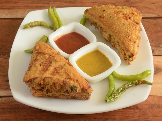 Brood pakora of pakoda geserveerd met chutney een beroemde middagsnack in india geserveerd in witte plaat selectieve focus