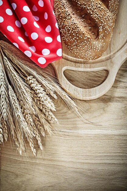 Brood snijplank rogge oren rode polkadot servet op houten achtergrond