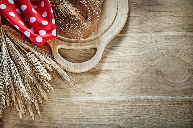 Brood snijplank tarwe oren rode polkadot servet op houten achtergrond