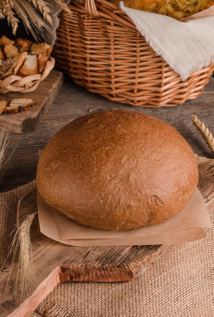 Brood van traditioneel rond roggebrood op houten achtergrond en jute