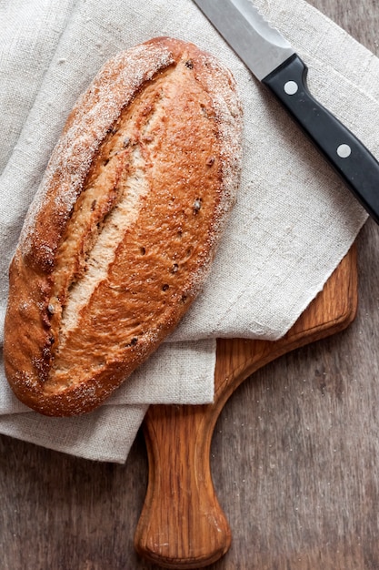 Brood van volkoren brood houten plank op keukentafel. plat lag, bovenaanzicht