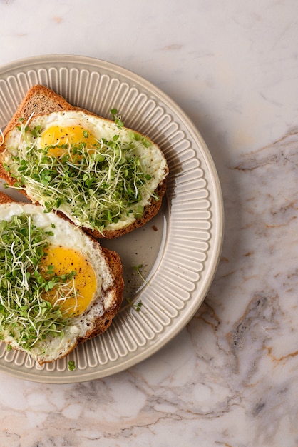 Foto broodje gebakken ei met microgreens.