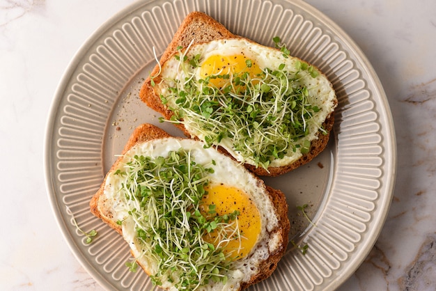 Broodje gebakken ei met microgreens.