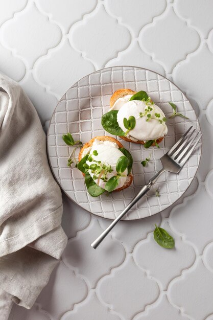Broodje gepocheerd ei met roomkaasspinazie en microgroenten Gezonde ontbijtbruschetta