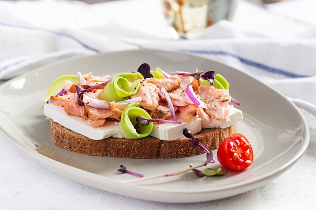 Broodje met gebakken zalm, fetakaas, avocado en microgreens