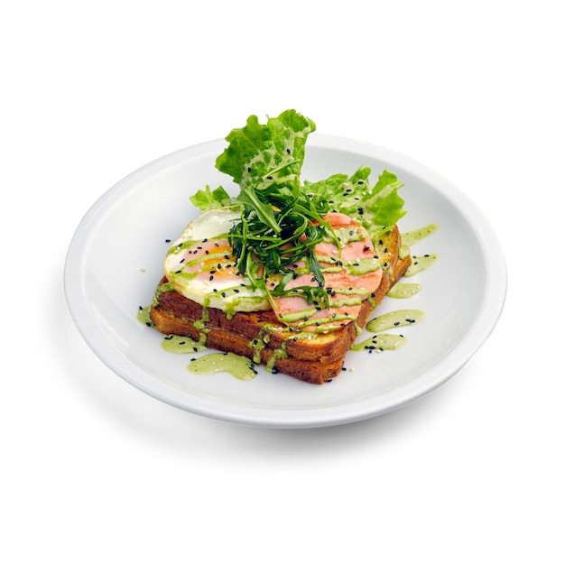 Broodje toast met sla, ei, ham, kaas en saus De sandwich is versierd met rucola en sesamzaadjes Ontbijt in een café Geïsoleerd object op een witte achtergrond