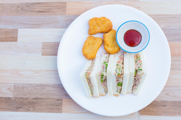 Broodje Tonijn met Groenten werd geserveerd met kipnuggets en tomatensaus als ontbijtmaaltijd