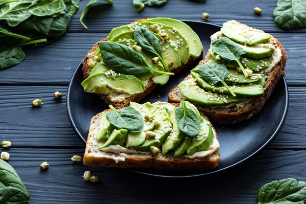 Broodjes met avocado en spinazie op een bord