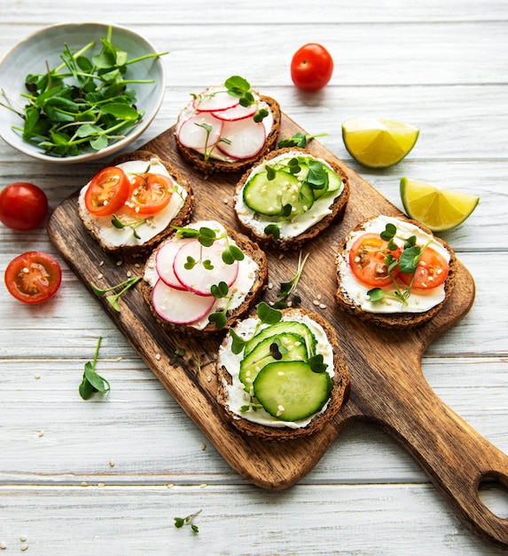 Broodjes met gezonde groenten en micro Groenen op een houten tafel, bovenaanzicht