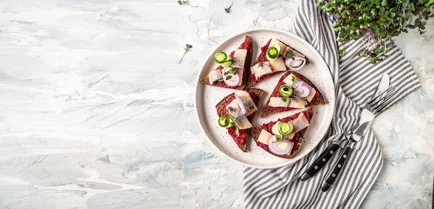Broodjes met haringuien en rode bietsalade verse komkommer Traditie Deense open sandwich smorrebrod met herrin Lang spandoekformaat bovenaanzicht