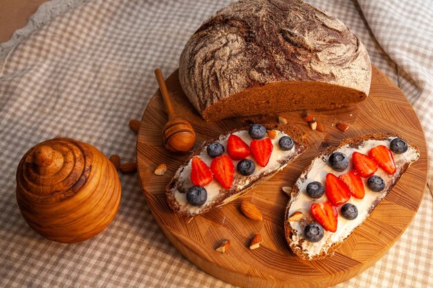 Broodjes met huisgemaakt roggebrood, honing, kaas en bessen