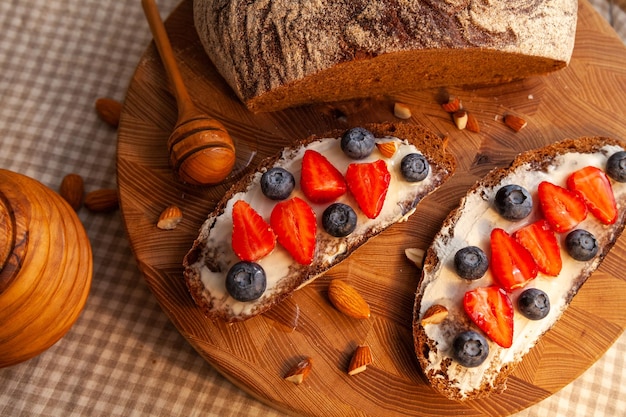 Foto broodjes met huisgemaakt roggebrood, honing, kaas en bessen