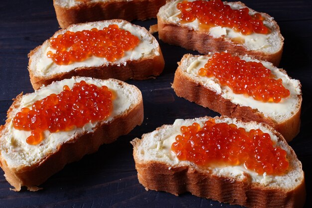 Broodjes met rode kaviaar op een donkere achtergrond