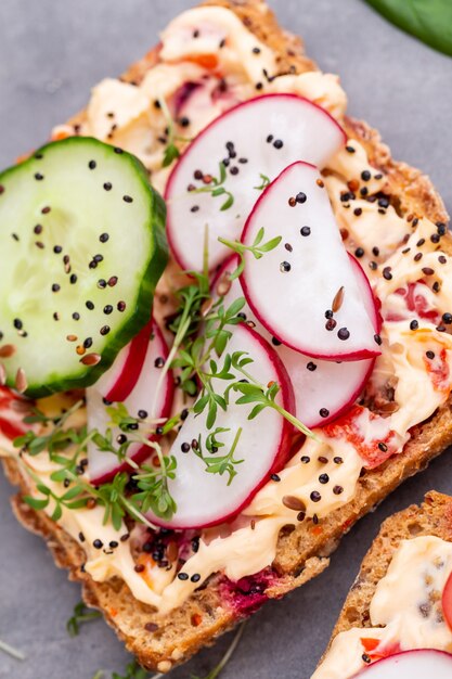 Broodjes met roomkaas, groenten en salami.