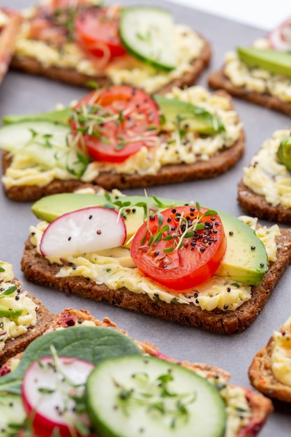 Broodjes met roomkaas, groenten en salami.