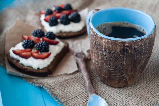 Broodjes met zoete kaas en bessen, een kopje koffie