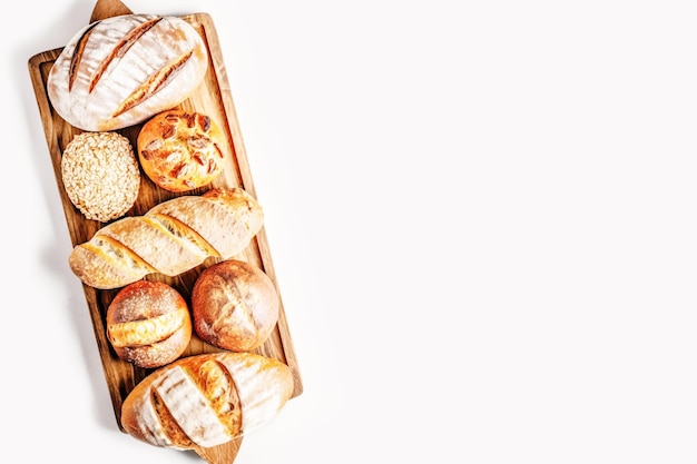 Broodjes stokbrood zoet broodje en croissant op houten bord op witte achtergrond met kopie ruimte