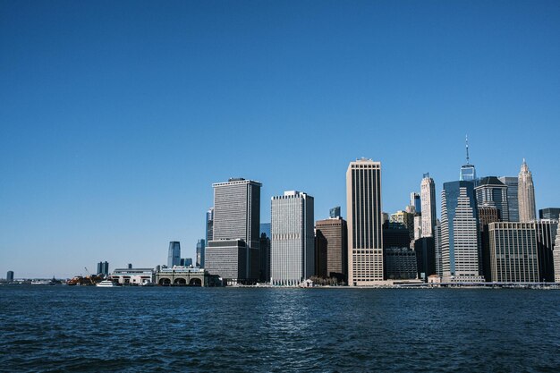 Brooklyn bridge from pebble beach at golden hour with the entire ny skyline brooklyn