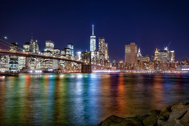 Brooklyn Bridge over de East River tegen het verlichte Manhattan's nachts.