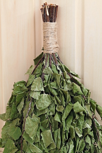 Broom birch twigs for Russian sauna. On a wooden surface.